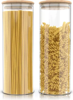 Two glass storage jars filled with pasta, one with spaghetti and the other with fusilli, are shown side-by-side on a white background.