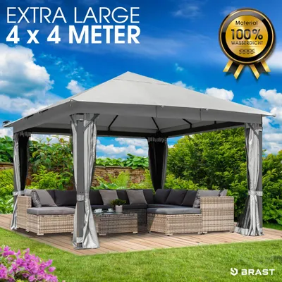 A gazebo with outdoor furniture set up on a wooden deck in a garden.