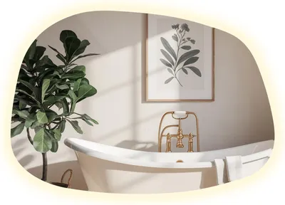 A modern bathroom with a freestanding bathtub, a plant, and framed artwork on the wall.