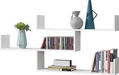 A white wall-mounted shelf unit displaying decorative items and media.