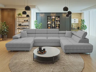 A spacious living room with a large sectional sofa, coffee table, and decorative shelving.