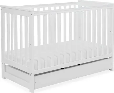 A white baby crib with a drawer underneath, shown from a slightly elevated side angle against a white background.