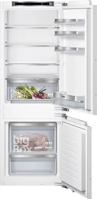 The interior of a white refrigerator with the door open, showing shelves and drawers.