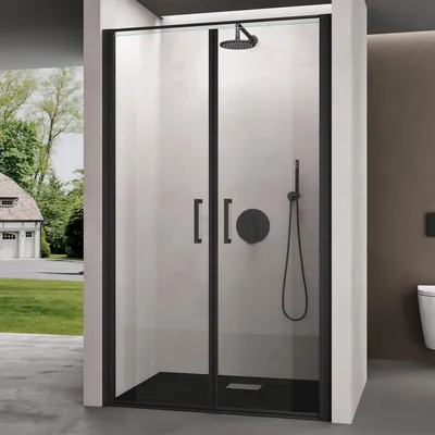 A modern shower enclosure with black framing and clear glass doors, set against a light gray tiled wall and a brown wall, with a view of a house and garden through a side opening.