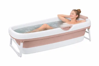 A woman relaxing in a portable bathtub filled with water.