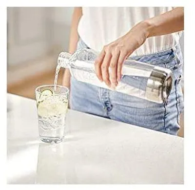 A person is pouring water from a bottle into a glass.