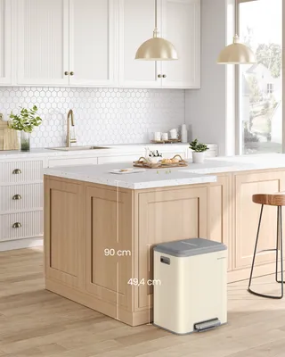 A modern kitchen with a wooden island and a cream-colored trash can next to it.