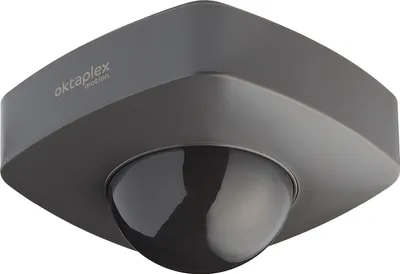 A close-up, angled view of a gray Oktaplex motion sensor with a black dome.