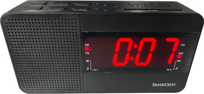 A black Silvercrest digital alarm clock with a red LED display showing the time.