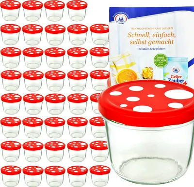 A collection of small glass jars with red and white mushroom-shaped lids, alongside a recipe booklet.