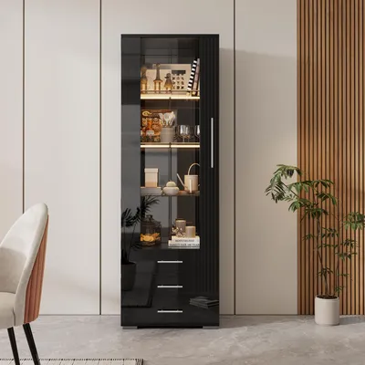 A black high-gloss display cabinet with LED lighting and three drawers, filled with decorative items, is shown in a room with a chair and a potted plant.