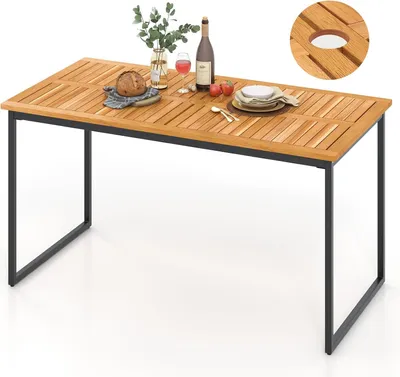 A rectangular wooden table with a black metal frame, set up outdoors with some items on it.