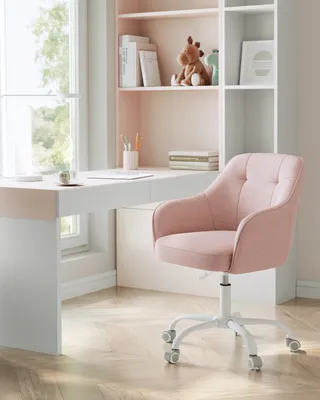 A pink office chair next to a white desk with a bookshelf in the background.