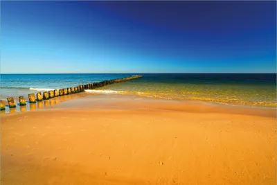 Produktbild von Wallario Premium Vliestapete Fototapete Sandstrand in orange - Blaues Meer - Blauer Himmel in der Größe 400 x 267 cm, extra dick, wird in 5 Teilen geliefert