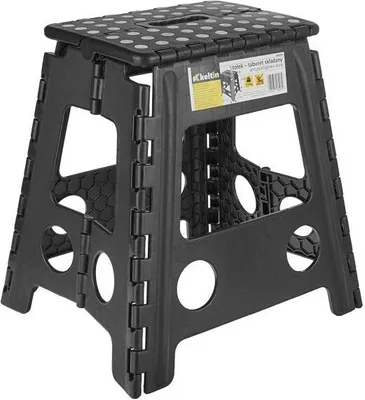 A black folding stool with white dots on the top surface, shown from the front.