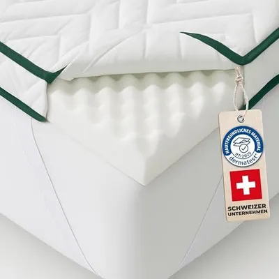 A close-up view of a mattress topper, showing its layered construction and a tag attached.