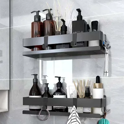 Two black bathroom shelves mounted on a tiled wall, filled with various toiletries and accessories.