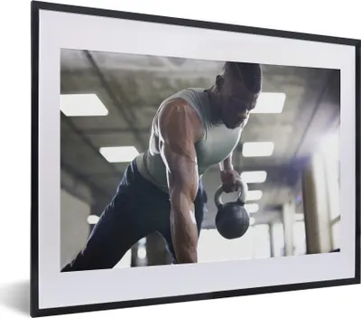 Produktbild von MuchoWow® MuchoWow® Gerahmtes Poster Ein starker Mann hebt Kettlebells beim Fitness 40x30 cm - Poster mit zchwarzem Bilderrahmen - Bilderrahmen - Poster im Rahmen