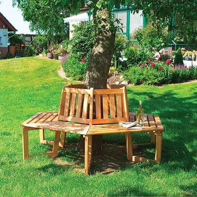 A wooden bench surrounds a tree in a garden.