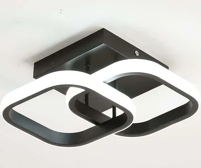 A modern LED ceiling light fixture with two interlocking square-shaped frames, mounted on a black square base against a white ceiling.