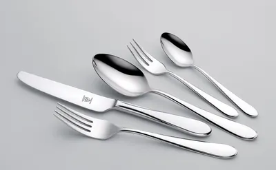 A set of silverware, including a knife, two spoons, and two forks, is arranged on a light gray background.