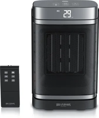 A black electric heater with a remote control on a white background.