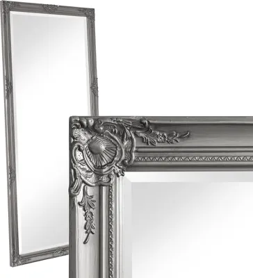 Two ornate silver mirrors are shown against a white background. One mirror is in the foreground, showing a close-up of its decorative frame, while the other is in the background, showing its full length.