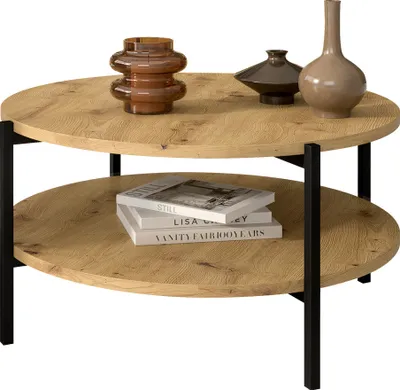 A two-tiered round coffee table with decorative items on top and books on the bottom shelf.
