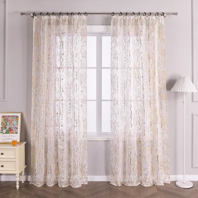 A window with sheer curtains and a bedside table with a framed picture.