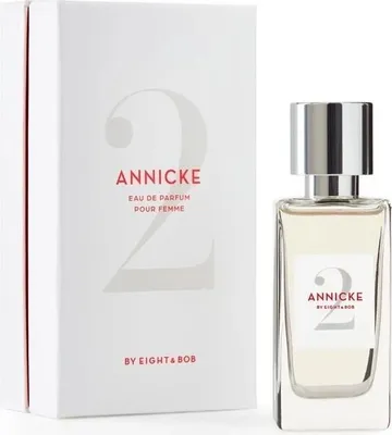 A perfume bottle and its packaging are displayed side-by-side against a white background.