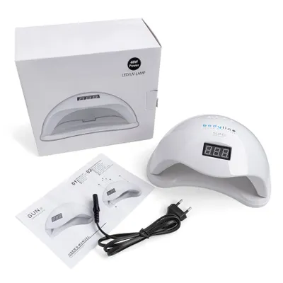 A white LED UV nail lamp, its packaging, and user manual are laid out on a white background.