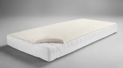 A mattress topper on a mattress.