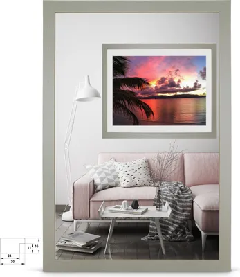 A living room scene with a pink sofa, coffee table, and a framed picture of a sunset over the ocean.