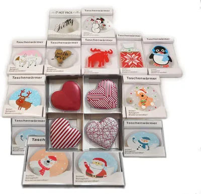 A collection of hand warmers with various festive and seasonal designs, arranged in a grid.