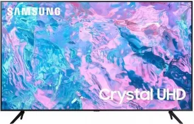 A Samsung Crystal UHD TV is displayed on a stand against a colorful, abstract background.