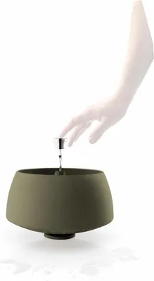 A hand reaching towards a salad spinner.