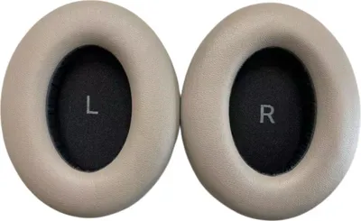 Two beige ear pads for headphones, each with a black inner surface marked with 'L' and 'R'.