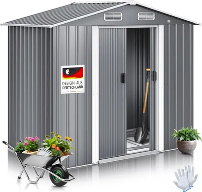 A garden shed with gardening tools and plants displayed in front of it.