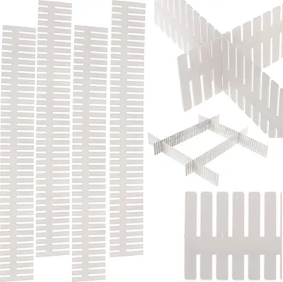A collection of white plastic drawer dividers arranged in various configurations.