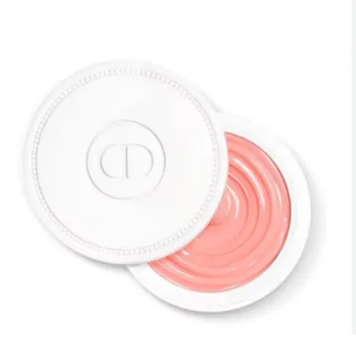 A top-down view of an open Dior Creme Abricot Fortifying Cream for Nails, showing the pink cream inside a white circular container with the Dior logo on the lid.