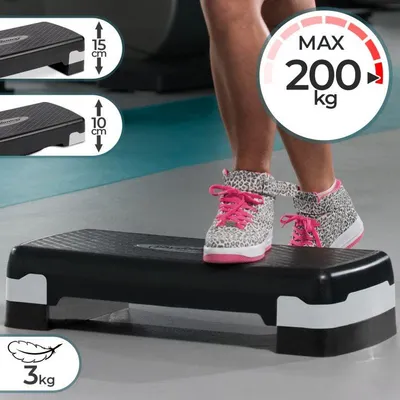 A person's legs and feet wearing leopard-print sneakers with pink laces are stepping on a black aerobic stepper in a gym setting. The stepper has white accents on the sides. There are inset images showing the stepper at different heights and a graphic indi