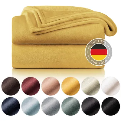 A stack of yellow fleece blankets with a circular logo showing the German flag and text.