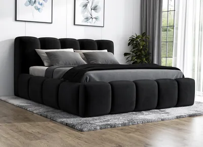 A modern black upholstered bed with a tufted headboard and frame, set on a gray rug in a room with artwork and a window.