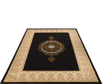 A black rug with an oriental pattern in gold and white, shown from a diagonal angle on a white background.
