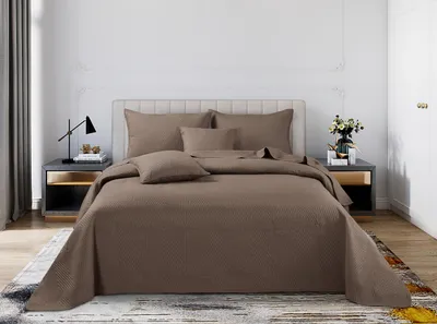 A neatly made bed with brown bedding in a bedroom setting.