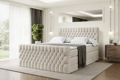 A bedroom scene featuring a large, tufted boxspring bed.
