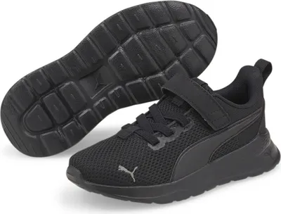 A pair of black Puma sneakers for children, shown from a slightly elevated side-angle with one shoe's sole visible.