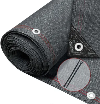 A rolled-up piece of dark gray mesh fabric with red stitching and metal grommets, likely a privacy screen or shade cloth.