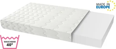 A white mattress with a wavy pattern on the top surface, partially covered by a white sheet. A separate white foam block is shown next to it. There are two icons on the left and top right.