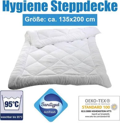 A white quilted blanket is shown folded on a white background, with various certification logos and text overlays.
